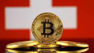 Physical version of Bitcoin (new virtual money) and Switzerland Flag. Conceptual image for investors in cryptocurrency and Blockchain Technology in Switzerland.