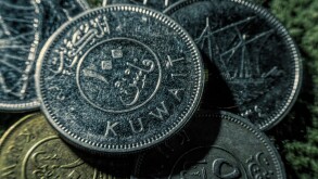 Coins of dinars, Kuwait national currency and lines from the Quran