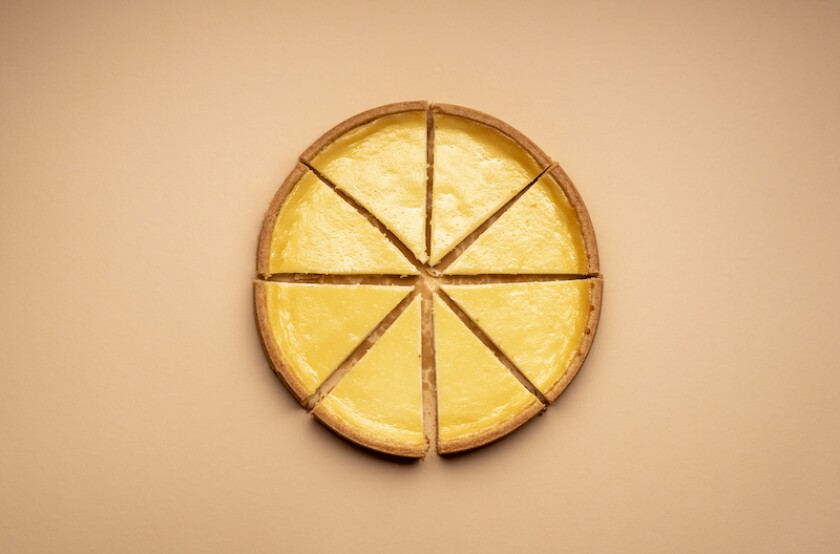 Sliced cheesecake on a yellow background. Equal sliced cake
