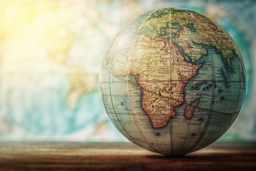 Adventure stories background. Old globe on map background. Selective focus.