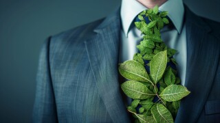 Sustainable Business: Man Wearing Green Tie Made of Leaves - A businessman wearing a suit with a green tie made of leaves, symbolizing sustainability, environmental consciousness, growth, nature, and responsibility.