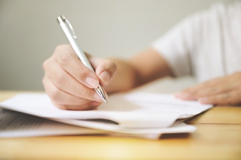 Hand of man signing signature filling in application form document