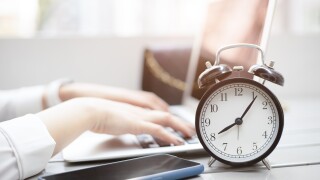 Business working times concept people work typing on laptop computer overlay with in time clock in the morning