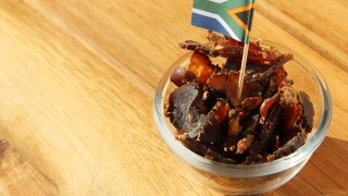 Biltong (dried meat) on a wooden board, this is a traditional food snack that can be found in South Africa.