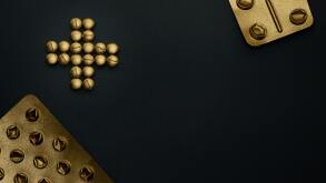 Two sets of medical tablets, with pills forming a plus sign between them