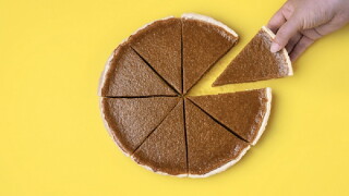 Sliced pumpkin pie. Taking a pie slice.