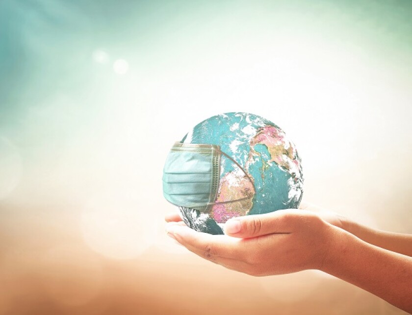 COVID-19 prevention concept: Human hands holding earth globe with medical disposable face mask. Elements of this image furnished by NASA