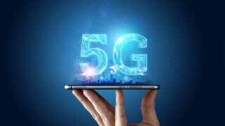 Creative background, male hand holding a phone with a 5G hologram on the background of the city. The concept of 5G network, high-speed mobile Internet, new generation networks. Copy space, Mixed media.
