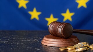 Gavel of judge with coins against European Union flag