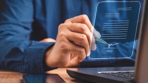 A businessman using a pen signing electronic documents on digita