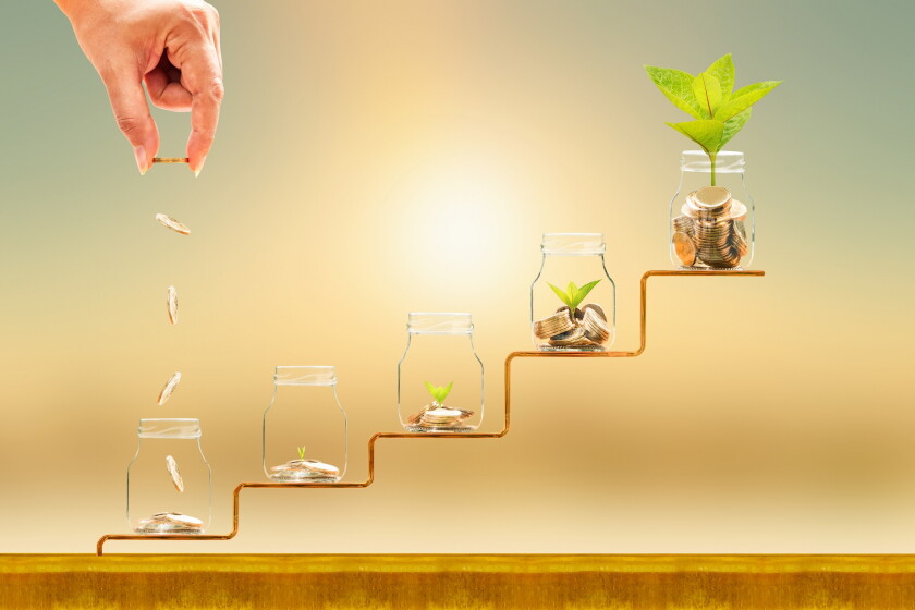 Investor hand hold and drop a gold coin in the five bottle and p