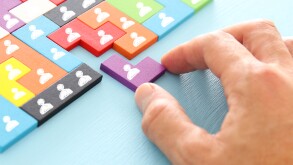 image of tangram puzzle blocks with people icons over wooden table ,human resources and management concept.