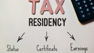 Tax residency text and flowchart with calculator on desk.