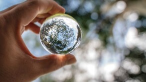 Reflection of blue sky, white clouds and trees in a glass ball i