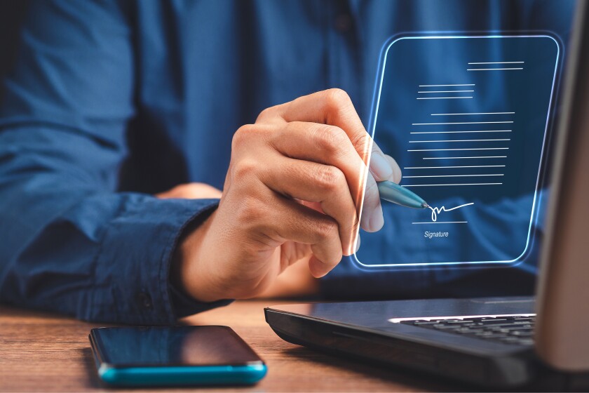 A businessman using a pen signing electronic documents on digita