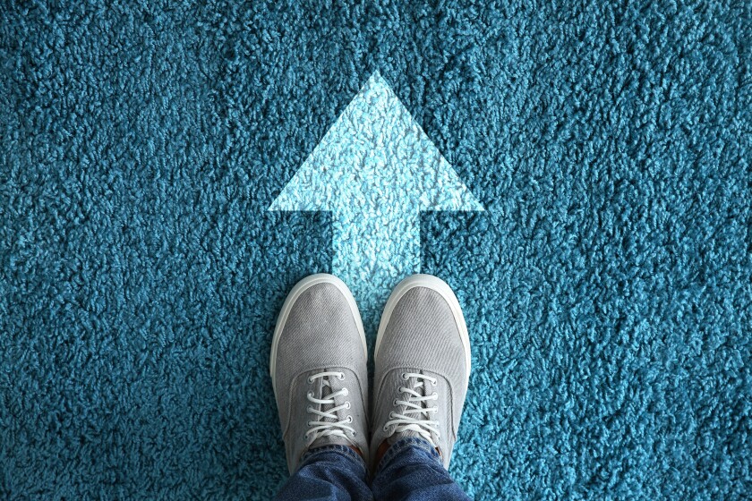 Man standing on carpet with arrow pointing in one direction. Con