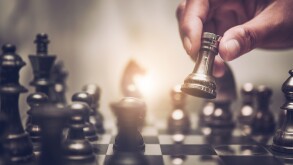 Businessman moving chess piece on chess board game concept for i