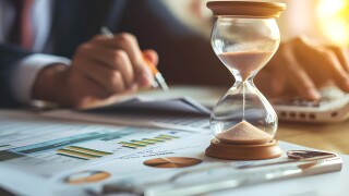 Hourglass on a business  desk and important documents
