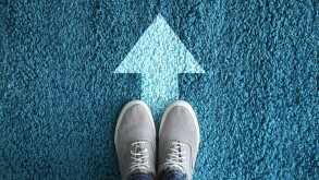 Man standing on carpet with arrow pointing in one direction. Con