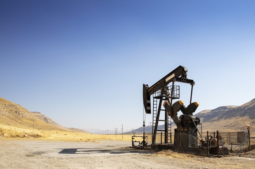 Oil drilling derricks at desert oilfield. Crude oil production from the ground. Oilfield services contractor. Oil drill rig and pump jack. Petroleum production, natural gas, liquids, NGL, additive.