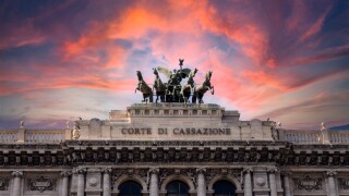 Pink dramatic skies during sunset over the bronze horses at corte di cassazione supreme court in Rome, italy.