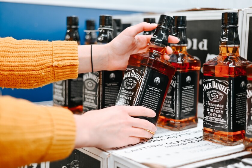 Close-up of a woman shopper holding a bottle of Jack Daniel's American whiskey brand in a store, buying alcohol. Astana, Kazakhstan 02.18.2024