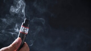 Electronic cogarette vape on a dark background with steam