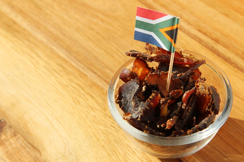 Biltong (dried meat) on a wooden board, this is a traditional food snack that can be found in South Africa.