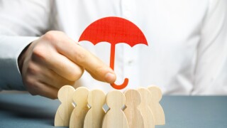Boss holding a red umbrella and defending his team with a gesture of protection. Life insurance. Customer care, care for employees. Security and safety in a business team. Selective focus