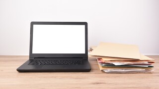 Back Laptop and Document file placed on the desk.