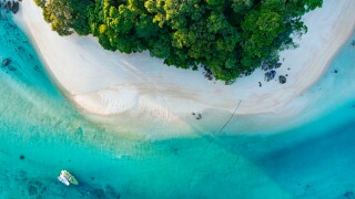 Top view of white sand beach tropical  with seashore as the island in a coral reef ,blue and turquoise sea Amazing nature landscape with blue lagoon