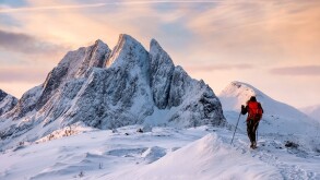 Mountaineer man climbs on top snowy mountain