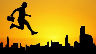 Silhouette of a man jumping in the meadow. The business concept