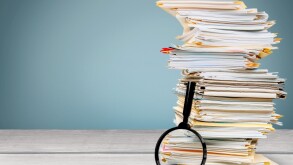 File folders with documents and magnifying glass on the desk