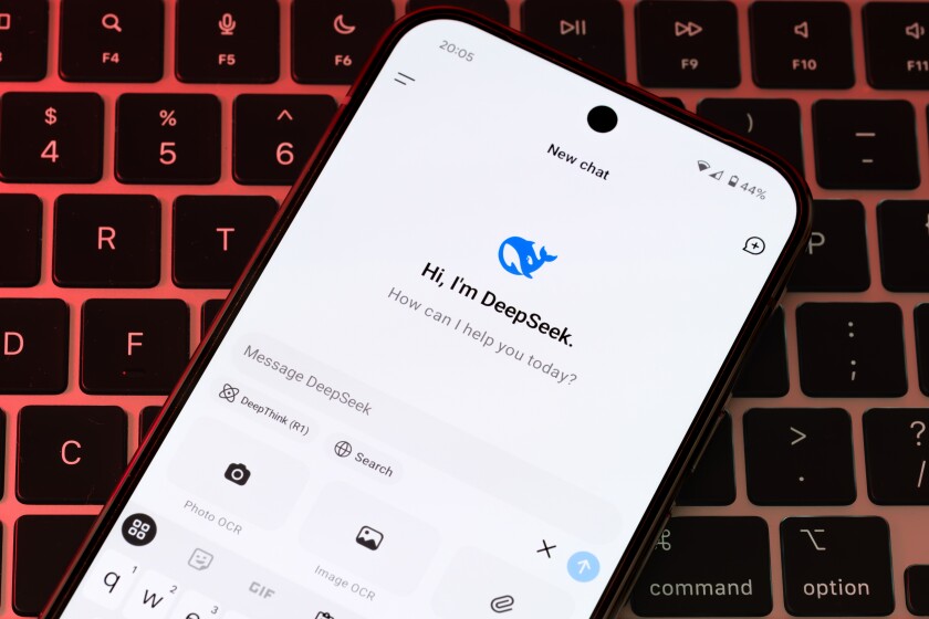 DeepSeek AI interface is seen on the smartphone placed on laptop keyboard. Concept for a new chat bot, competitor to Chat GPT. Stafford, United Kingdom, January 26, 2025