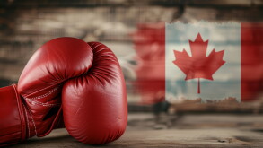 Red boxing gloves positioned in front of a Canadian flag backdrop, symbolizing strength and national pride in combat sports.