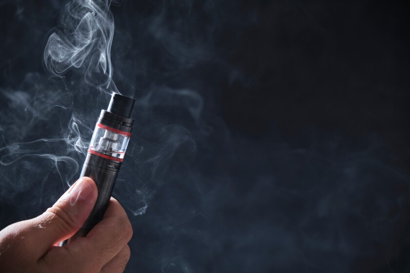 Electronic cogarette vape on a dark background with steam