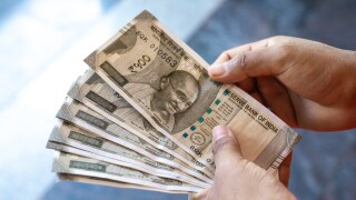 A woman counting Indian rupee notes of 500