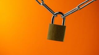 padlock connecting a metal chain on an orange background. Web banner.
