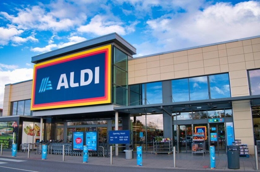 The frontage and brand logo of a branch of German discount retailer Aldi, taken in a local retail park on Wirral, UK on a sunny afternoon