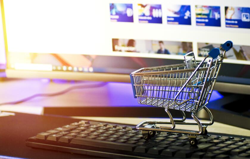 Mini shopping trolley on keyboard in front of monitor