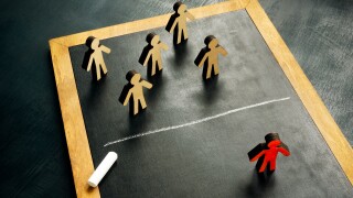 Social exclusion concept. Figurines and a chalk line separating them.