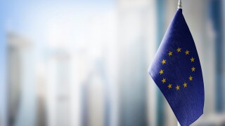 Small national flags of the European Union on a light blurry background
