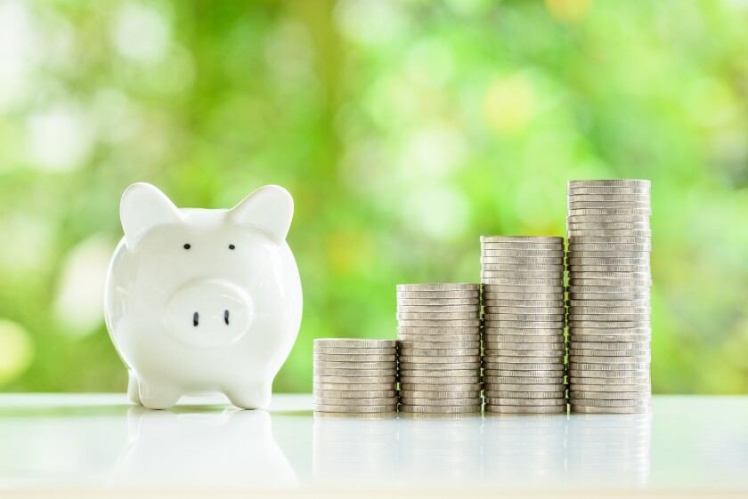 A cheerful piggybank with stacks of shiny coins nearby, represen