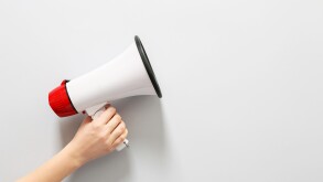 Female hand with megaphone on white background