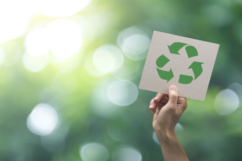 Hand holding recycle symbol on green bokeh background. eco and save the earth concept.