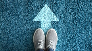 Man standing on carpet with arrow pointing in one direction. Con