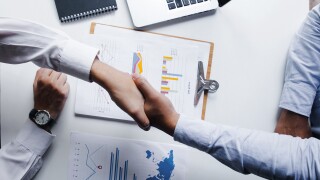 Handshake over financial reports.jpg
