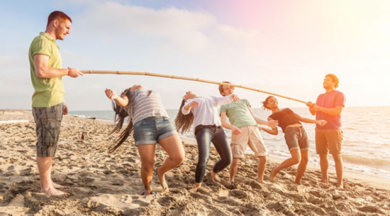 Friends Dancing Limbo at Beach