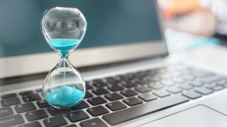 Hourglass on laptop computer concept for time management